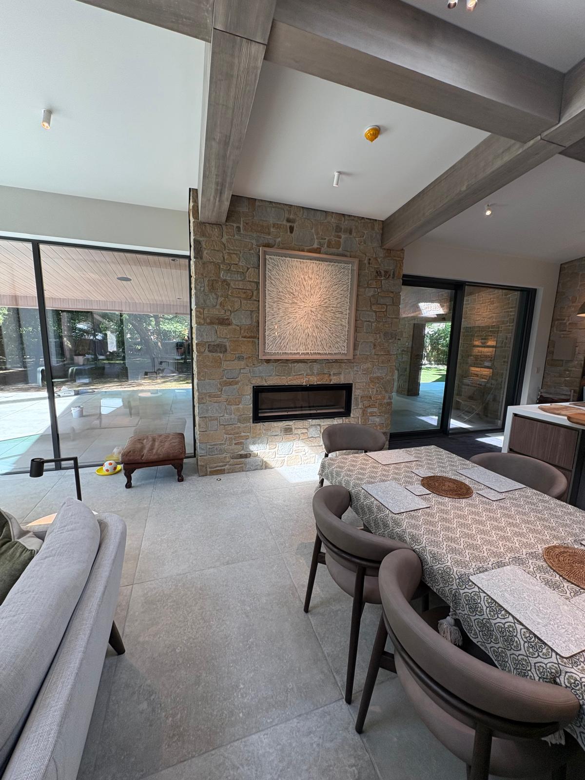 Living space with stone fireplace surround and large-format floor tiles