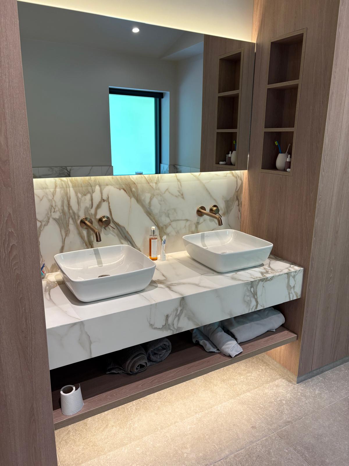 His-and-hers vanity with twin square basins and book-matched marble splashback